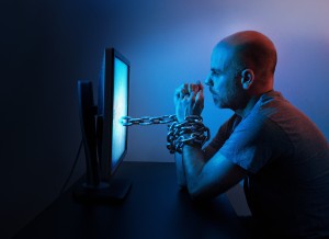 Man chained to his computer.