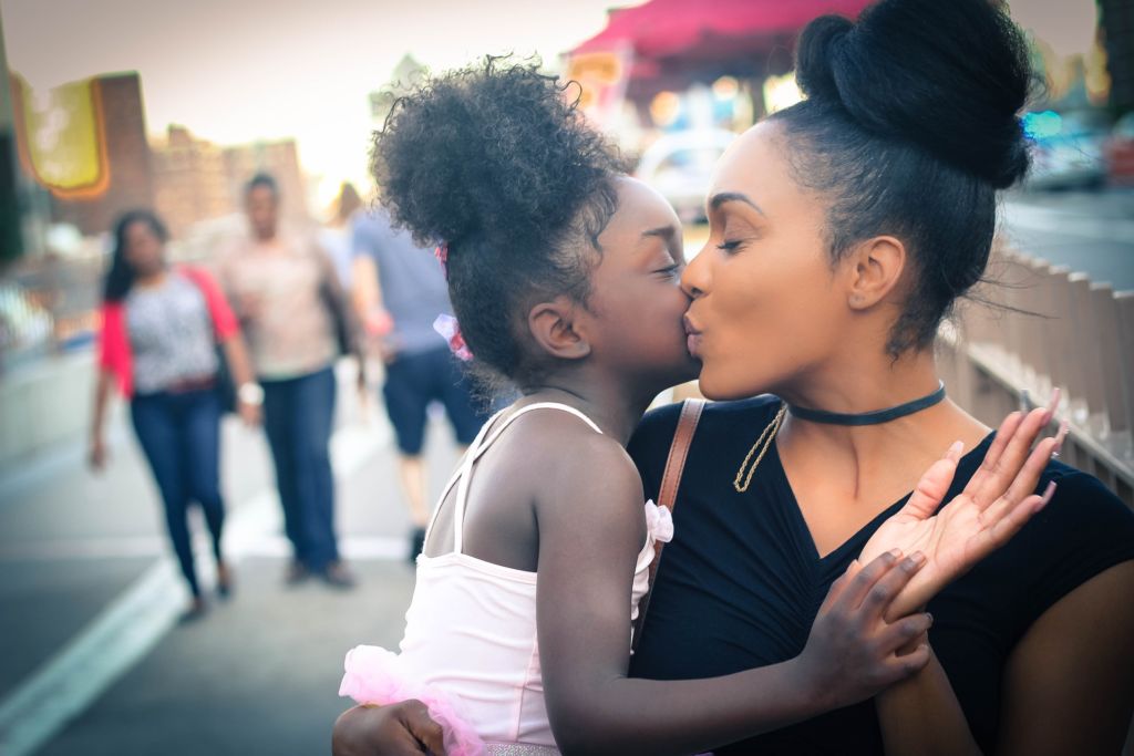 Picture of a mother kissing her daughter. 